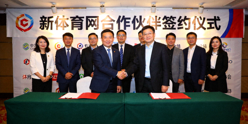 新体育网合作伙伴计划启动签约仪式现场，多位企业代表在台上握手合影