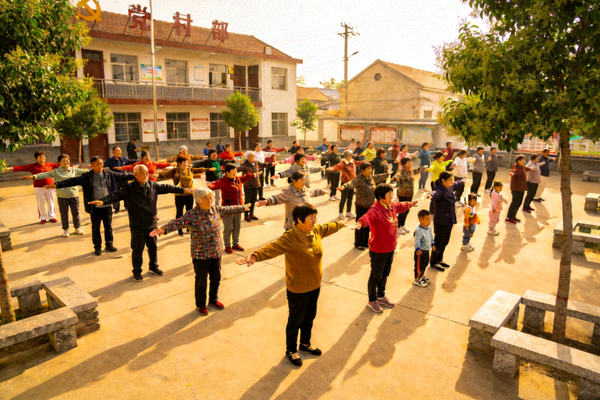 乡村广场上举行全民健身体操比赛，各年龄层村民整齐划一地表演