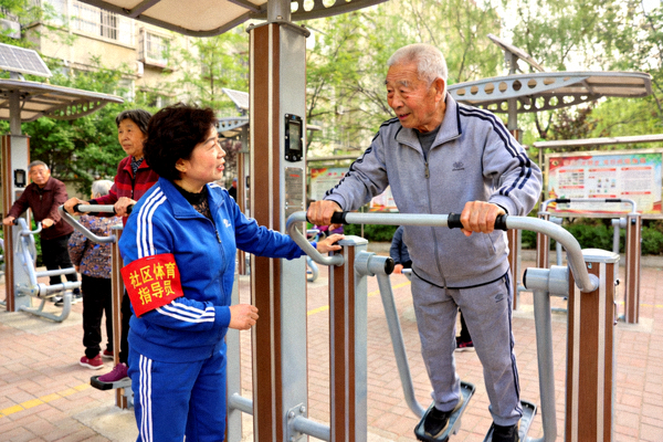 社区体育指导员正在指导居民正确使用健身器材