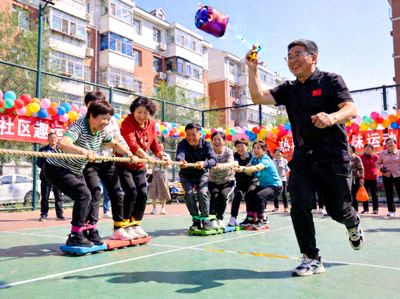 社区举办的趣味运动会现场，居民们正在参与欢乐的集体比赛项目