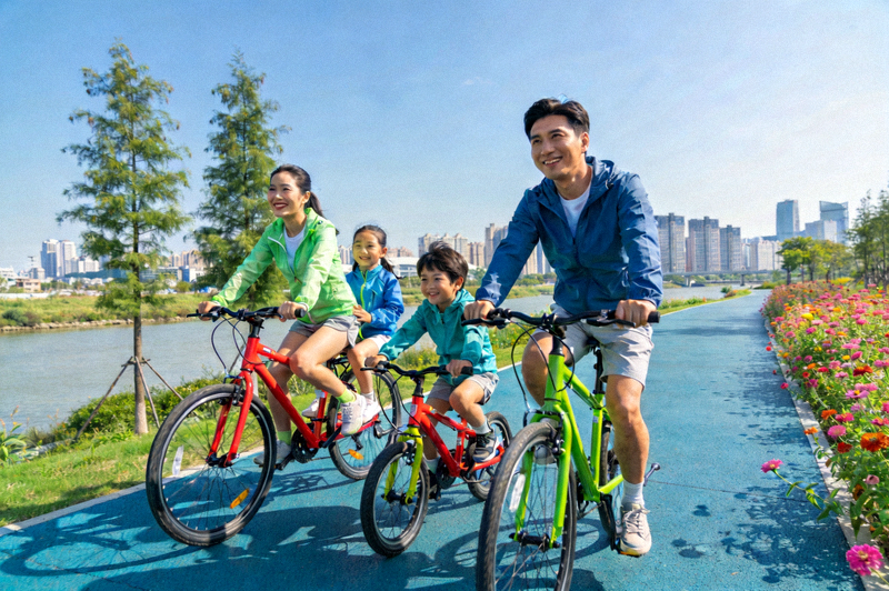 一个家庭在风景优美的城市滨水绿道上快乐骑行，享受健康周末时光