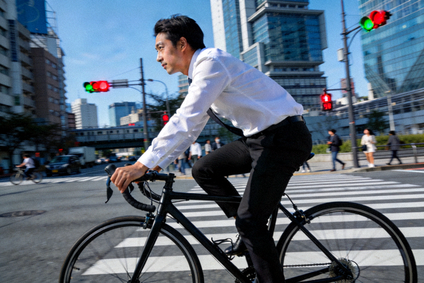 一位上班族选择骑自行车通勤，穿梭在城市街道中