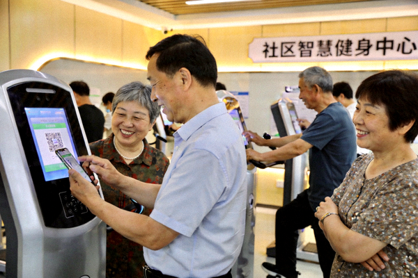 市民在新建的社区智慧健身中心扫码使用设备，现场气氛活跃